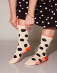 Person wearing polka dot socks with a plain background