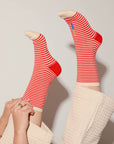 Red and white striped socks worn by a person with a neutral background