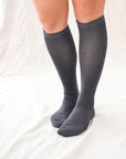 Elevate your style with our knee-high socks in classic grey, cream, and black. Luxuriously crafted for durability, these socks add a chic touch to any look. Made in South Korea. Small size (US women’s shoe size: 4-10.5)