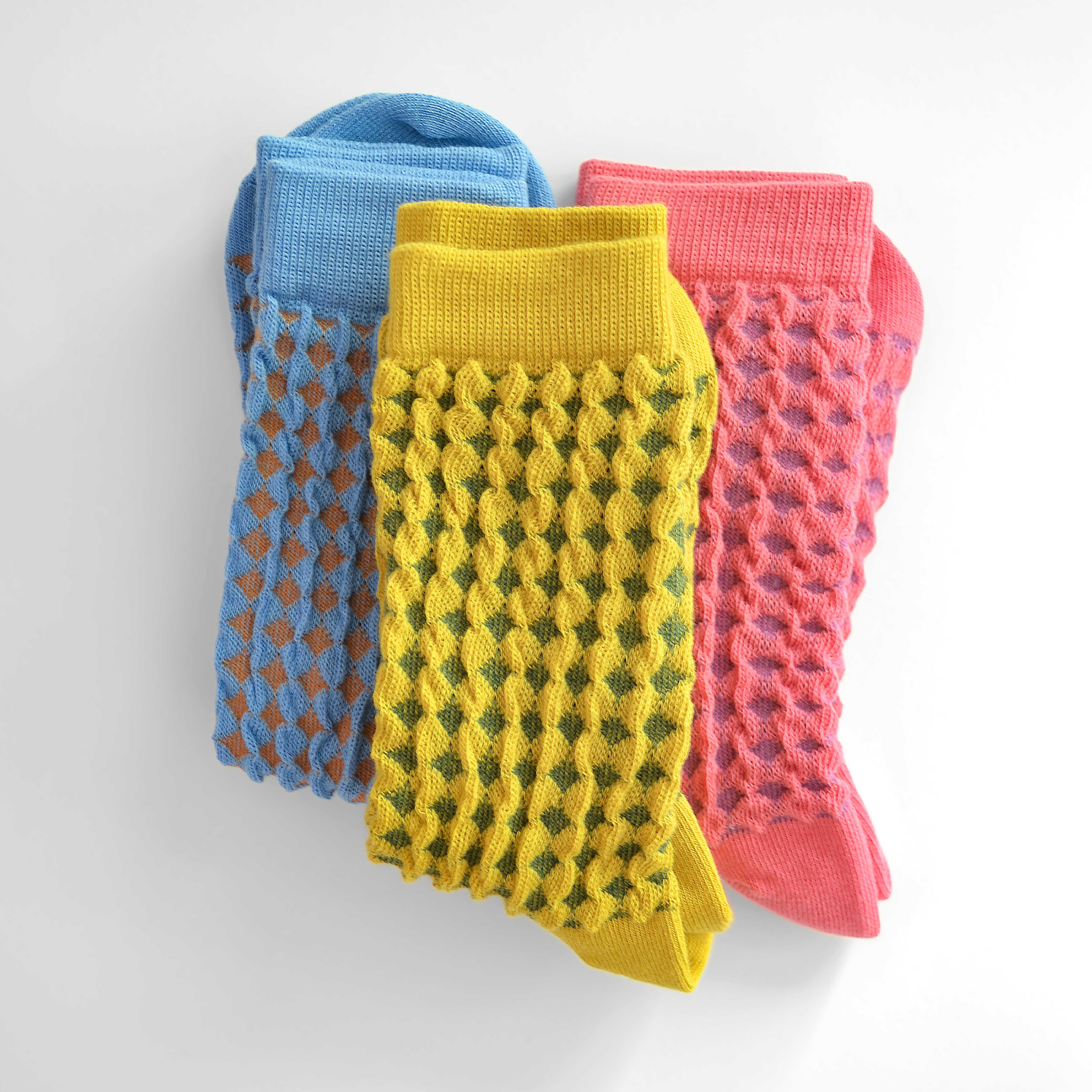 Hayes socks from Hooray Sock Co. Mid-crew length, textured ribbing, solid heel, toe, and contrasting color. In Mustard Yellow, Blue, Pink.