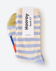 A delightful photograph showcasing our Greenwich Hooray Socks, a perfect blend of comfort and style. These crew socks feature a classic light blue and white stripe pattern with signature color bars. Crafted with 80% cotton and 20% spandex, they offer a lightweight and cozy feel. Made in South Korea, these unisex socks are available in two sizes: Large (Men's 8-12) and Small (Women's 4-10). Machine washable, no ironing needed; simply line dry for best results.
